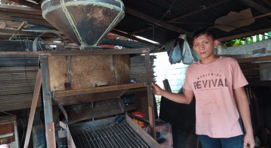 Kadri Mokoagow yang hanya lulus SMP saat menunjukan mesin pemecah cangkang kemiri buatannya, Senin (12/10/2020) di kediamannya, di Desa Bilalang 2 Kecamatan Kotamobagu Utara. (Foto: Erwin Makalunsenge/Bolmong.News)