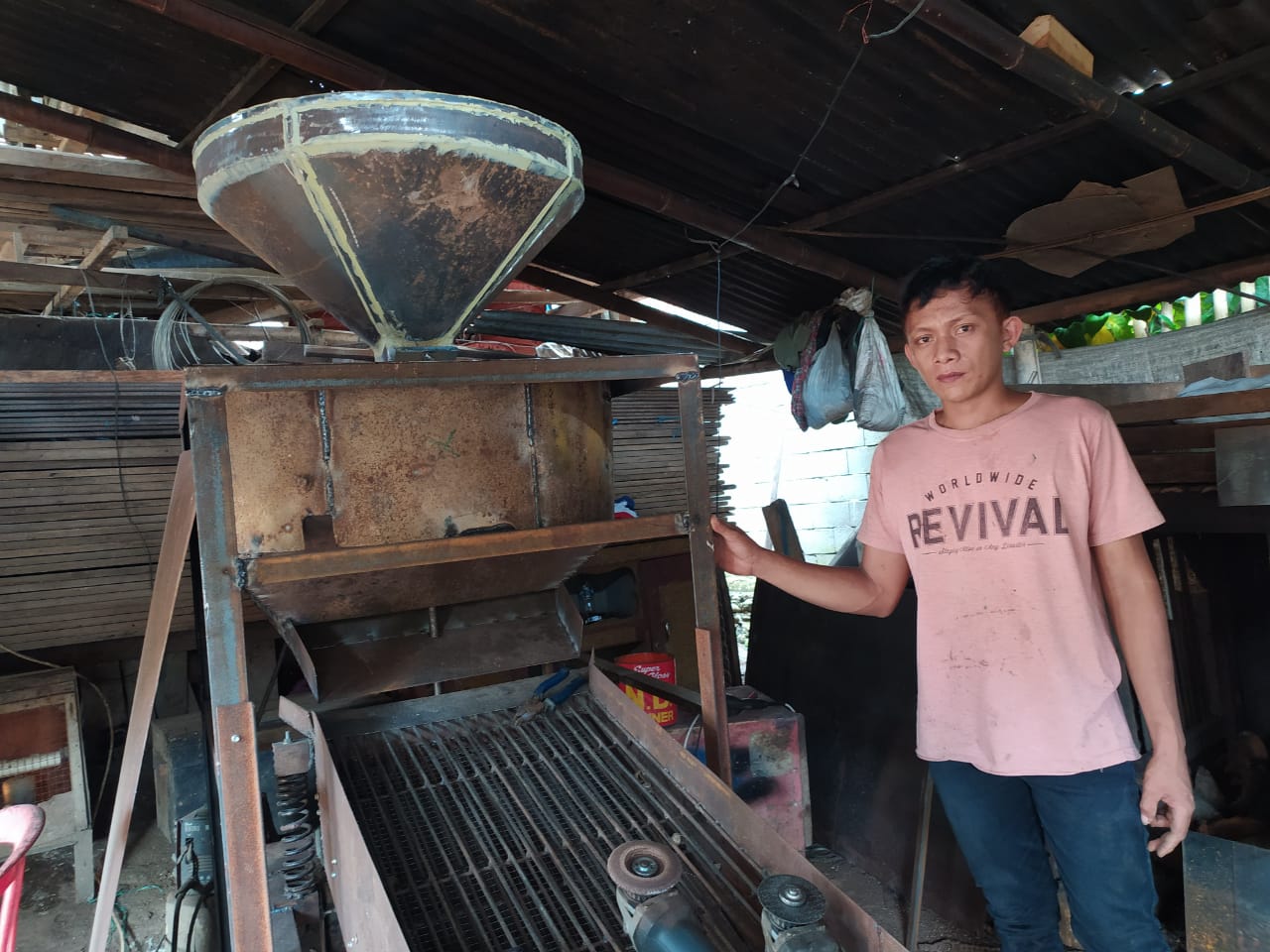 Kadri Mokoagow yang hanya lulus SMP saat menunjukan mesin pemecah cangkang kemiri buatannya, Senin (12/10/2020) di kediamannya, di Desa Bilalang 2 Kecamatan Kotamobagu Utara. (Foto: Erwin Makalunsenge/Bolmong.News)