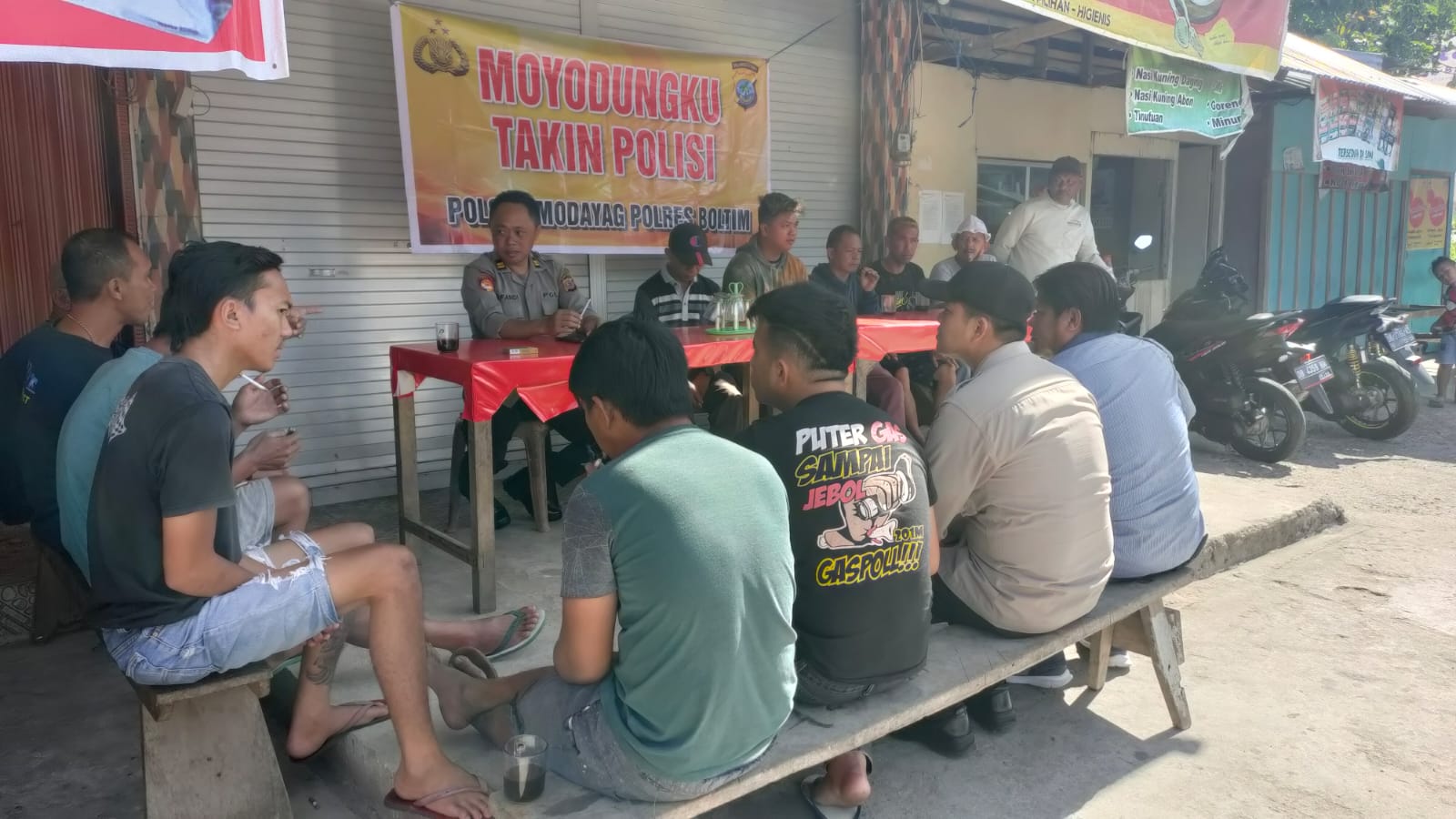 Kapolsek Modayag Iptu Irfandi Mokodongan bersama anggotanya dan para sopira ngkot serta pengendara ojek saat melakukan pertemuan pada kegiatan Moyodungkul Takin Polisi dan Curhat di pangkalan persatuan ojek Modayag desa Modayag Kecamatan Modayag,Jumat, 30 Desember 2022. (Foto: dok/Polsek Modayag)