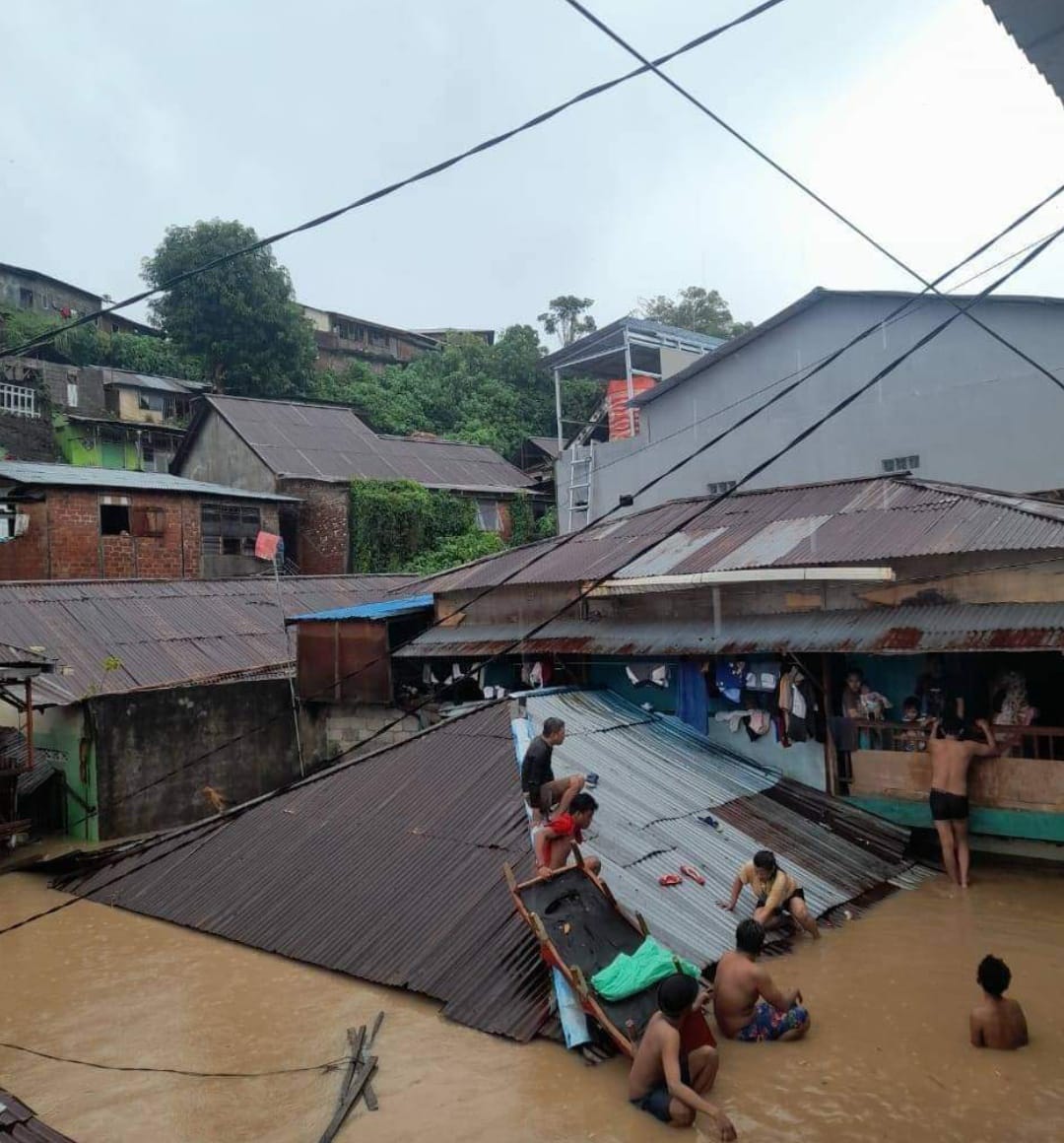 sejumlah warga Wonasa berada di atap rumah saat banjir bandang yang terjadi di wilayah Manado, Jumat (27/1/2023). Foto: Akun facebook Sulawesi Utara Community. 
