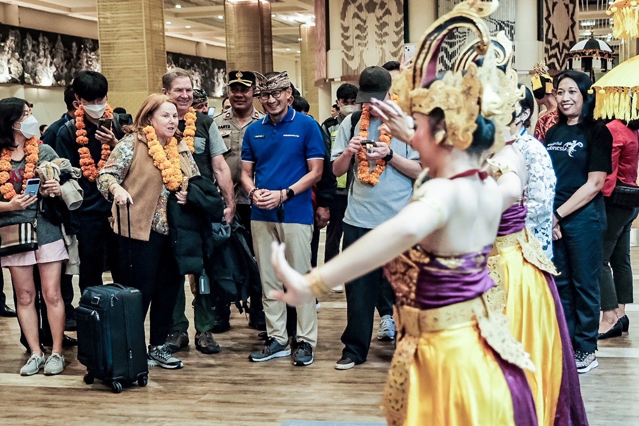 Menparekraf, Sandiaga Salahuddin Uno menyambut wisatawan pertama tiba di Indonesia Tahun 2023, di di Bandar Udara Internasional Ngurah Rai, Bali, Minggu, 1 Januari 2023. Foto: dok/Kemenparekraf.go.id