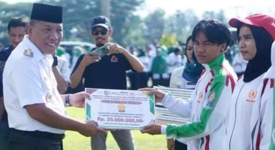 Bupati Bolmut Depri Pontoh menyerahkan bonus berupa uang sebesar Rp25 juta kepada atlet yang meraih medali emas di Porprov Sulut ke-Xi, di halaman Kantor Bupati Bolmut, Rabu (4/1/2023). Foto: Dok/Humas Pemkab Bolmut.