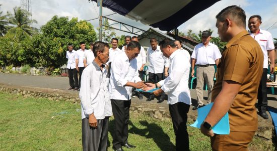 Bupati Boltim Sam Sachrul Mamonto menyerahkan SK kepada dua orang staf khusus saat apel kerja, Senin (30/1/2023). Foto: Gazali Potabuga