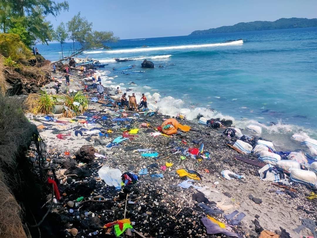 Pakaian bekas yang berhamburan di pantai Kawasari Kecamatan Aer Tembaga Kota Bitung, yang diangkut Kapal Penyelundup diduga dari Negara Malaysia, Selasa (17/1/2023). Foto: tangkapan layar dari akun Facebook Sulawesi Utara Community.