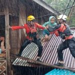 Tim Basarnas Manado mengevakuasi salah satu anak akibat banjir Manado, Jumat (27/1/2023). Foto: Akun Facebook, Sulawesi Utara Community.