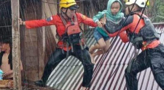 Tim Basarnas Manado mengevakuasi salah satu anak akibat banjir Manado, Jumat (27/1/2023). Foto: Akun Facebook, Sulawesi Utara Community.