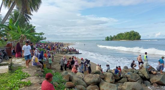 Ratusan warga berdiri di pinggiran Pantai Desa Buko menunggu pencarian terhadap korban Marwah Yusuf yang tenggelam terseret ombak, Minggu (8/1/2023) sekira pukul 14.30 wita. Foto: Indra Matoka.