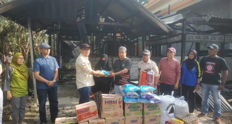 Asisten III Pemkot Kotamobagu Moh Agung Adati memberikan bantuan kepada pemilik rumah yang terbakar di Kelurahan Motoboi Besar, Sabtu (25/2/2023). Foto: Dok/Diskominfo Kotamobagu.