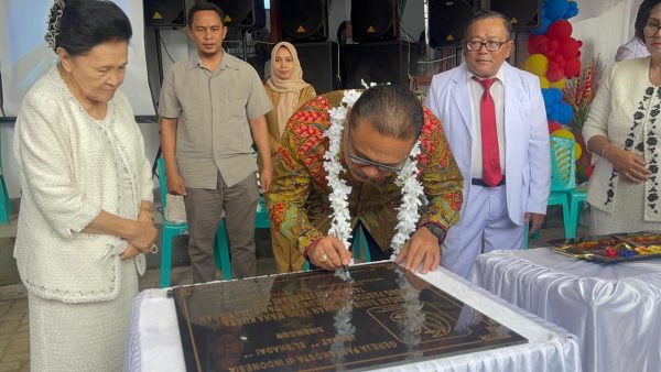 Tampak Penjabat Bupati Limi Mokodompit, saat tandatangani prasasti Gedung Pastori GPDI El Shadai Sinsingon sebagai tanda telah diresmikannya bangunan tersebut, di Kecamatan Passi Timur, Kabupaten Bolmong, Selasa 21 Februari 2023. (foto.dok/Dinas Kominfo Bolmong)