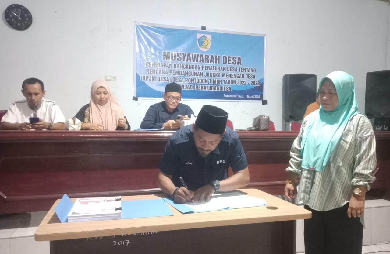 Ketua BPD Desa Pontodon Timur, Abdul Marham Koikit menandatangani berita acara Musdes Ranperdes tentang RPJMDes tahun 2022-2028 Perdes, Rabu (29/3/2023). Foto: Miranty Manangin.