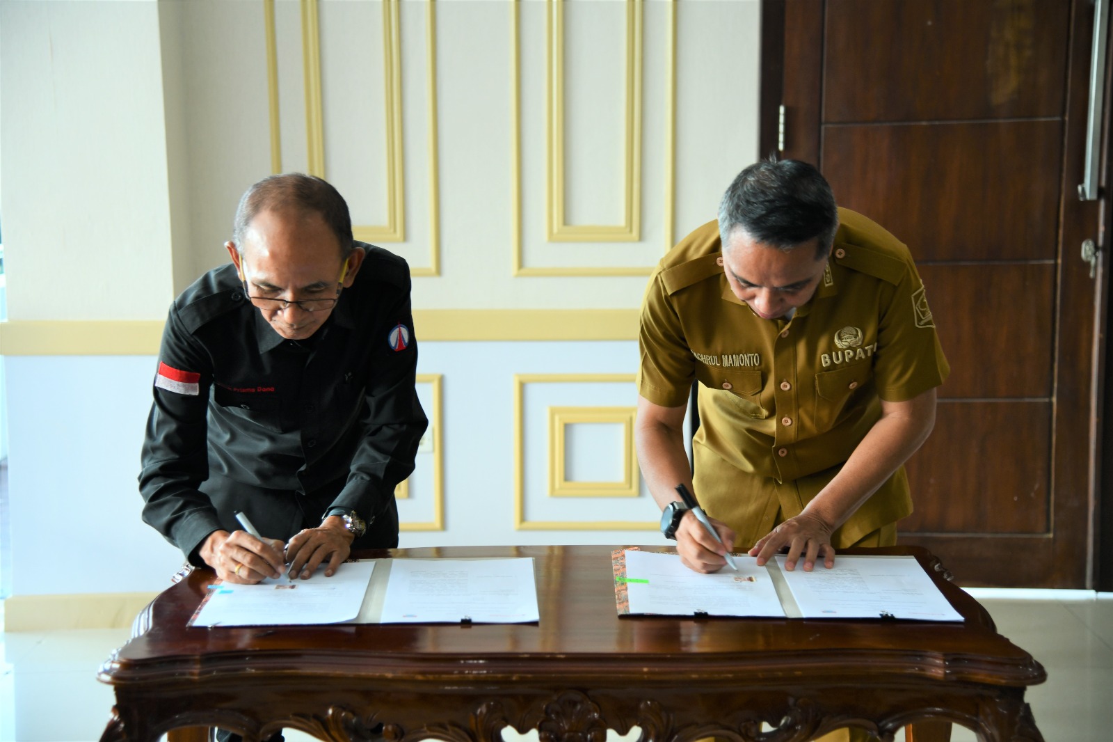 Bupati Boltim Sam Sachrul Mamonto sedang menandatangani MoU bersama Direktur PT Bank Prisma Dana, Johanis Ch. Salibana, yang dilaksanakan di ruang kerja Bupati Bolrim, Selasa (14/3/2023). Foto: Gazali Potabuga/bolmong.news.