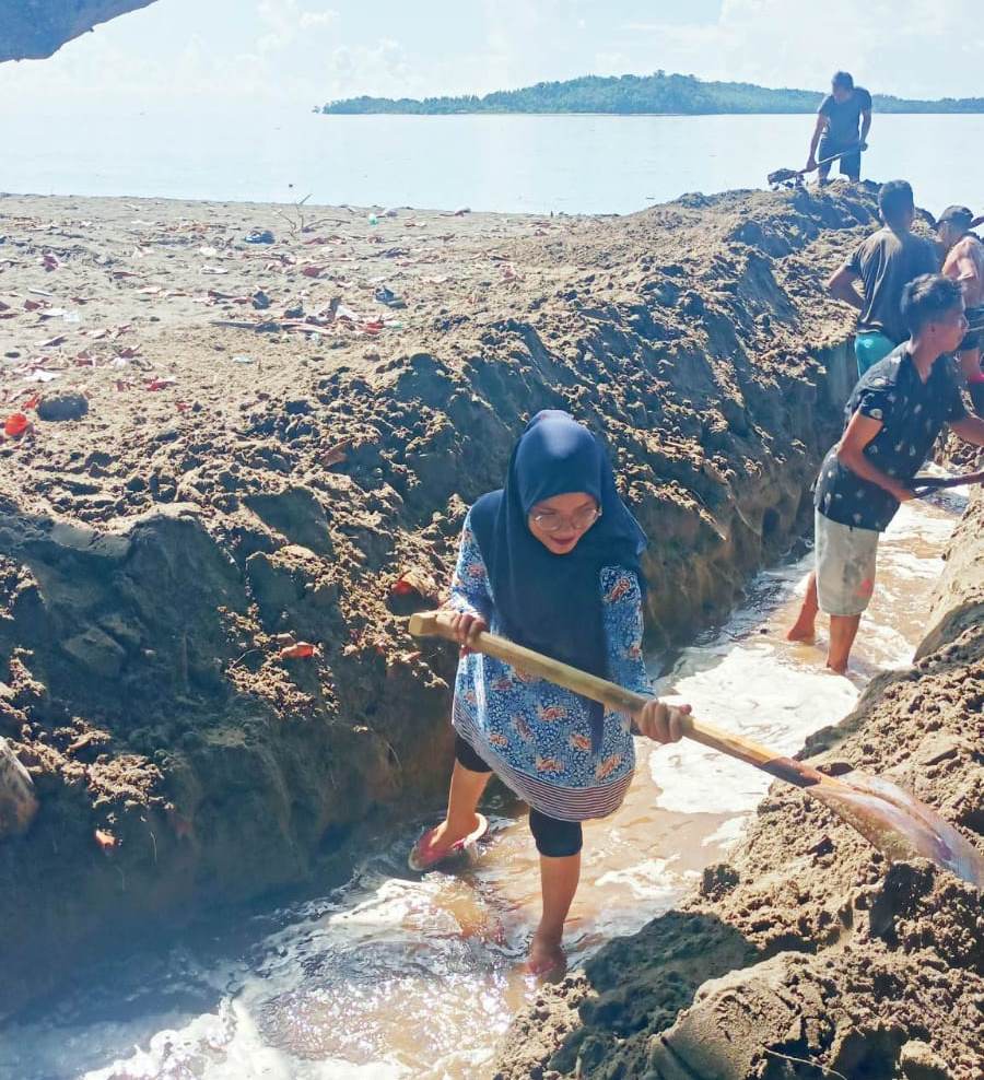 Sangadi Paret Timur Yuliana Potabuga memimpin kerja bakti bersama masyarakat di muara sungai antara perbatasan Desa Paret dan Kayumoyondi, Kamis (27/4/2023). Foto: Gazali Potabuga/bolmong.news