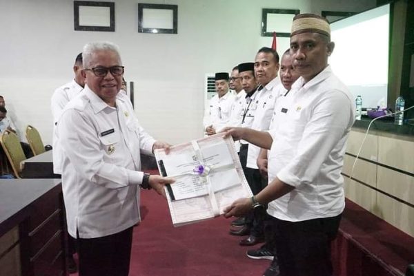 Wakil Bupati Bolmut Amin Lasena, saat memberikan secara simbolis SPPT dan PBB-P2 2023 kepada salah satu Camat yang bertempat di ruang rapat kerja BPKD Bolmut, Rabu 17 Mei 2023. (foto.Muchtar L Harundja/bolmong.news)