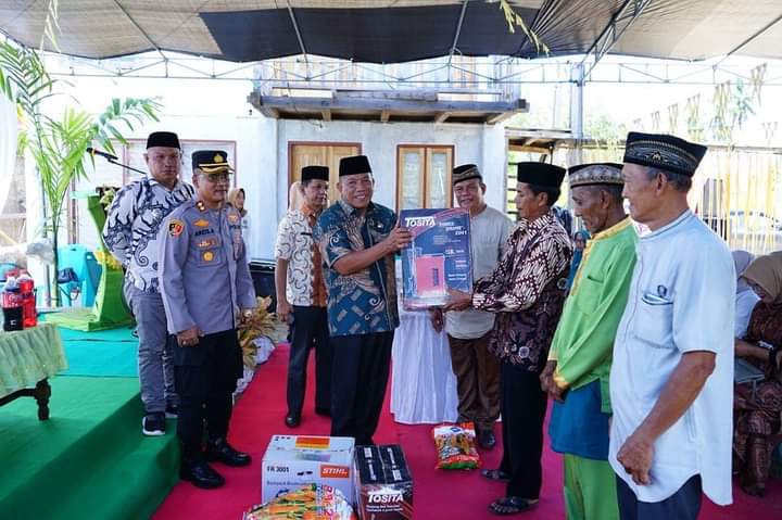 Bupati Depri Pontoh saat menyerahkan bantuan secara simbolis berupa alat pertanian kepada salah satu orang penerima manfaat usai acara Halal Bihalal di Desa Bolangitang 1, Bolmut, Kamis 4 Mei 2023. (foto.Muchtar L Harundja/bolmong.news)