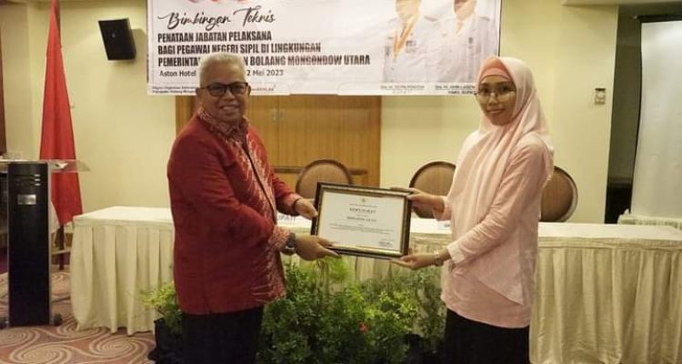 Wakil Bupati Bolmut Amin Lasena menyerahkan sertifikasi kepada salah satu peserta Bimtek penataan jabatan pelaksana bagi Pegawai Negeri Sipil di lingkungan Bolmut, Jumat (12/5/2023), di Hotel Aston Manado.