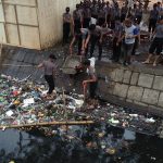 Personil Polda Sulsel melaksanakan membersihkan sampah di sungai, Kamis (13/7/2023). Foto: Muh Arifin