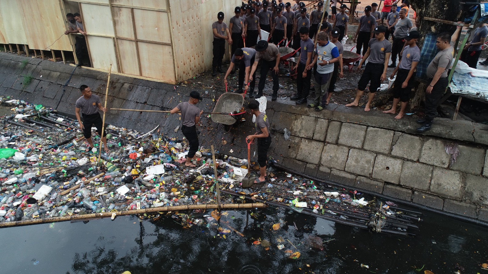 Personil Polda Sulsel melaksanakan membersihkan sampah di sungai, Kamis (13/7/2023). Foto: Muh Arifin