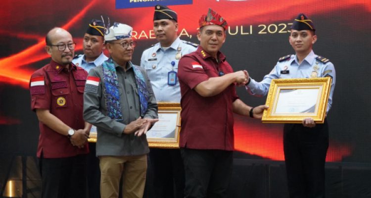 Tampak salah satu Petugas Imigrasi saat menerima penghargaan dari Dirjen Imigrasi Silmy Karim, di Aula Kantor Imigrasi Kelas I Khusus TPI Surabaya, pada Kamis 20 Juli 2023. (foto.Husnan/Imigrasi Kotamobagu)