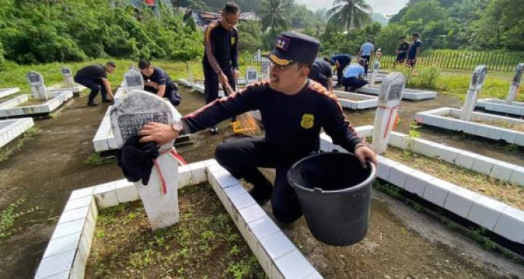 Tampak Karutan Kotamobagu Setyo Prabowo, saat membersihkan salah satu makam pahlawan di TMP Kotamobagu, Kelurahan Mongkonai, Kecamatan Kotamobagu Barat, Kamis 3 Agustus 2023. (foto.Rutan Kotamobagu)