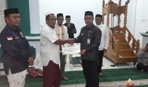 Penjabat Bupati Sirajudin Lasena menyerahkan bantuan dari Baznas