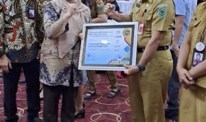 Kepala BKPP Bolmong Umarudin Amba (kanan), saat menerima Piagam BKN Award 2023, di Kantor Gubernur Sulawesi Utara (Sulut), Manado, Selasa 12 September 2023. (Foto.Diskominfo Bolmong)