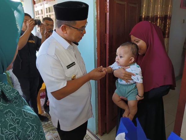 Tampak Penjabat Bupati Bolmut Sirajudin Lasena, saat menyapa seorang Ibu dan Bayinya, Rabu 11 Oktober 2023. (Foto.Muchtar L Harundja/bolmong.news)