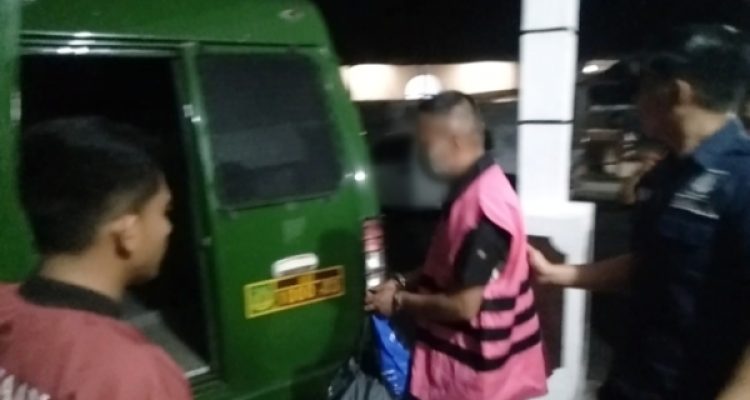 Tampak tersangka keluar dari Kantor Kejaksaan Kotamobagu saat mengenakan rompi pink tahanan dengan tangan diborgol, memasuki mobil tahanan Kejaksaan, Kamis 23 November 2023, malam. (Foto.Wahyudy Paputungan/bolmong.news)
