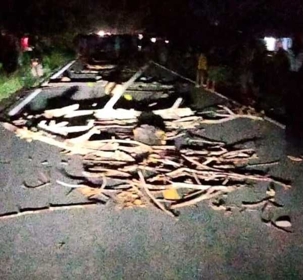 Tampak tumpukan kayu yang menutup badan jalan AKD. (Foto.Wahyudy Paputungan/bolmong.news)