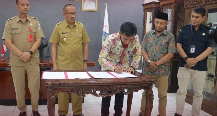 Penandatanganan NPHD untuk Pilkada 2024 yang ditandatangani oleh Pejabat Wali Kota Kotamobagu, Asripan Nani dan Ketua KPU Kotamobagu, Mishart A. Manoppo. (Foto: Miranty Manangin)