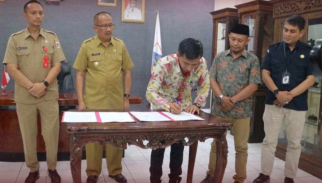 Penandatanganan NPHD untuk Pilkada 2024 yang ditandatangani oleh Pejabat Wali Kota Kotamobagu, Asripan Nani dan Ketua KPU Kotamobagu, Mishart A. Manoppo. (Foto: Miranty Manangin)