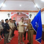 Tampak Pj Wali Kota Kotamobagu Asripan Nani menyerahkan pataka PWI kepada Ketua PWI Kota Kotamobagu Junaidi Amra, bertempat di Aula Rudis Wali Kota, Senin (29/1/2024). Foto: dok/Diskominfo Kotamobagu.