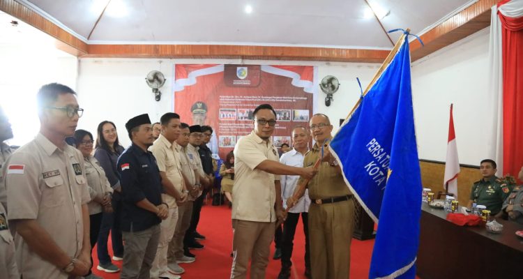 Tampak Pj Wali Kota Kotamobagu Asripan Nani menyerahkan pataka PWI kepada Ketua PWI Kota Kotamobagu Junaidi Amra, bertempat di Aula Rudis Wali Kota, Senin (29/1/2024). Foto: dok/Diskominfo Kotamobagu.