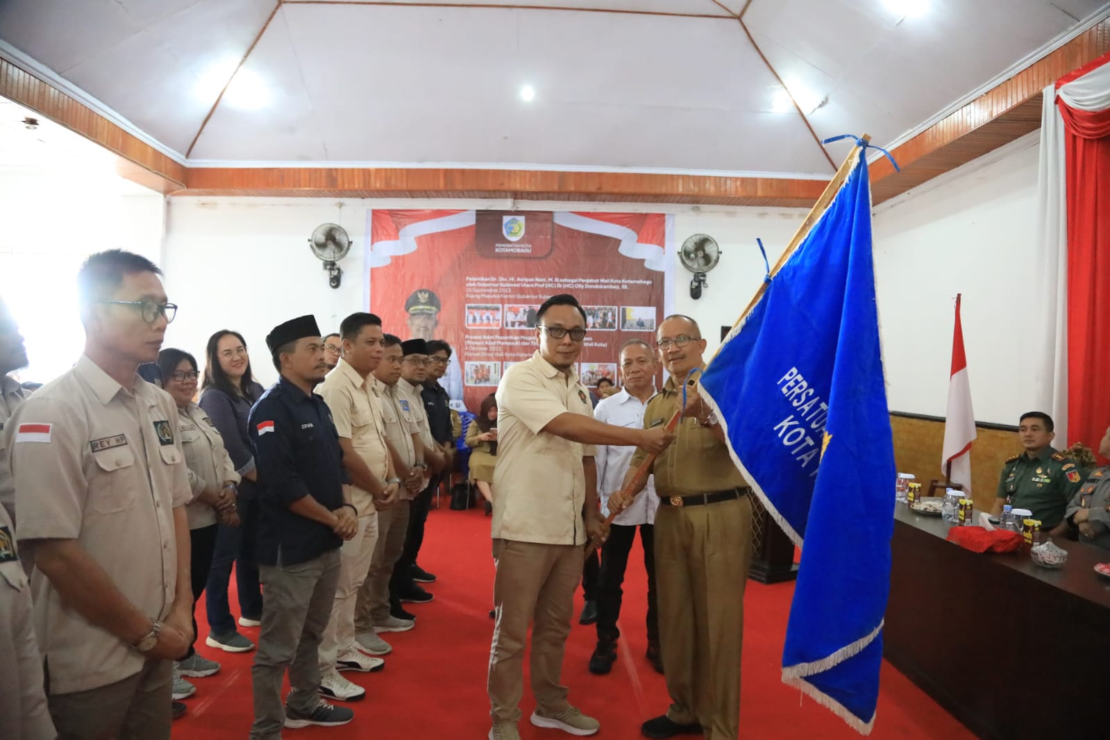 Tampak Pj Wali Kota Kotamobagu Asripan Nani menyerahkan pataka PWI kepada Ketua PWI Kota Kotamobagu Junaidi Amra, bertempat di Aula Rudis Wali Kota, Senin (29/1/2024). Foto: dok/Diskominfo Kotamobagu.