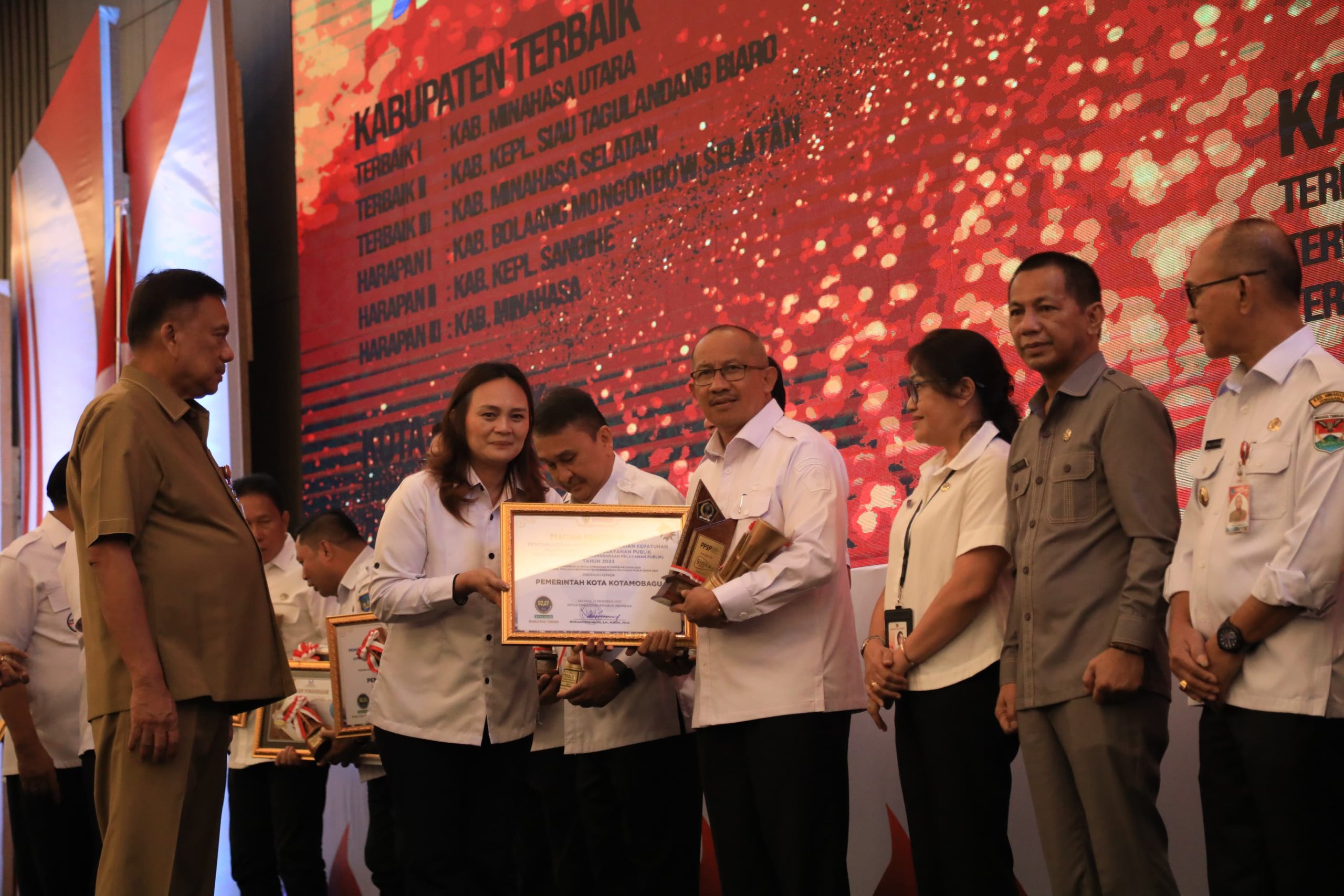 Kepala Perwakilan Ombudsman Republik Indonesia, Meilany F Limpar saat menyerahkan penghargaan kepada Pj Wali Kota Kotamobagu, Asripan Nani, Rabu (24/4/2024). Foto: Diskominfo Kotamobagu.