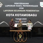 Kepala BPK RI Perwakilan Sulut, Arief Fadillah saat menyerahkan LHP dengan opini WTP kepada Pj Wali Kota Kotamobagu, Asripan Nani, di Aula Gedung BPK RI Perwakilan Sulut, Manado, Selasa (28/05/2024). Foto: dok/Diskominfo Kotamobagu