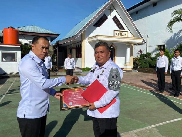 Tampak pegawai Rutan Kotamobagu mendapat apresiasi dari Karutan Kotamobagu Aris Supriyadi (kiri), berupa piagam penghargaan, di lapangan upacara Rutan, 29 Mei 2024. (Foto.Ilham/Rutan Kotamobagu)