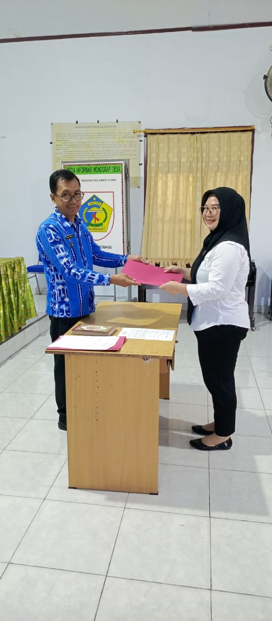 Ayu Pratiwi Gumalangit A.Md.Kebidana (kanan), saat menerima SK Sekdes Moyag Todulan yang diberikan Sangadi Roliadi Modeong (kiri), di Balai Desa Moyag Todulan, Kecamatan Kotamobagu Timur, Kita Kotamobagu, pada Kamis 30 Mei 2024. (Foto.Wahyudy Paputungan/bolmong.news) Ses Ayu, begitu sapaannya, dilantik langsung oleh Kepala Desa (Kades) atau Sangadi Moyag Todulan Roliadi Modeong, di Balai Desa Moyag Todulan, pada Kamis 30 Mei 2024.