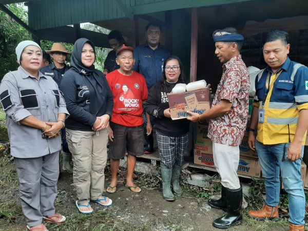 Pj Bupati Bolmong dr Jusnan Calamento Mokoginta, saat menyerahkan bantuan kepada salah satu warga terdampak banjir. (Foto.Wahyudi Paputungan/bolmong.news)