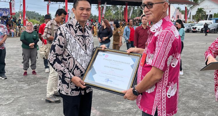 Kepala Dinas PP dan KB Kotamobagu, Ahmad Yani Umar saat menerima penghargaan di Hari Keluarga Nasional ke-31, Senin (22/7/2024). Foto: dok/Diskominfo Kotamobagu