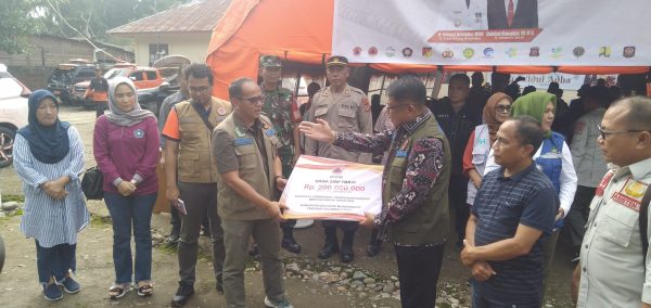 Sekda Bolmong Abdullah Mokoginta, saat menerima bantuan penanganan Banjir Dumoga dari BNPB, Sabtu 29 Juni 2024. (Foto.Wahyudi Paputungan/bolmong.news)