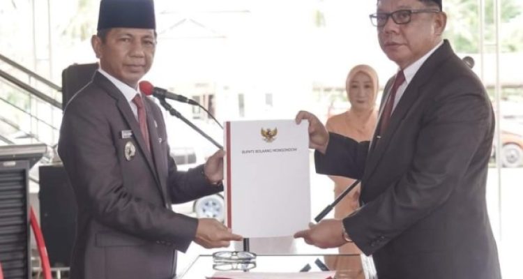 Penjabat Bupati Bolmong dr Jusnan Calamento Mokoginta MARS (kiri), saat menyerahkan SK Bupati pada Sekda Definitif Abdullah Mokoginta, di Pelataran Kantor Bupati Bolmong, Lolak, Senin 8 Juli 2024. (Foto.Istimewa/Diskominfo Bolmong)