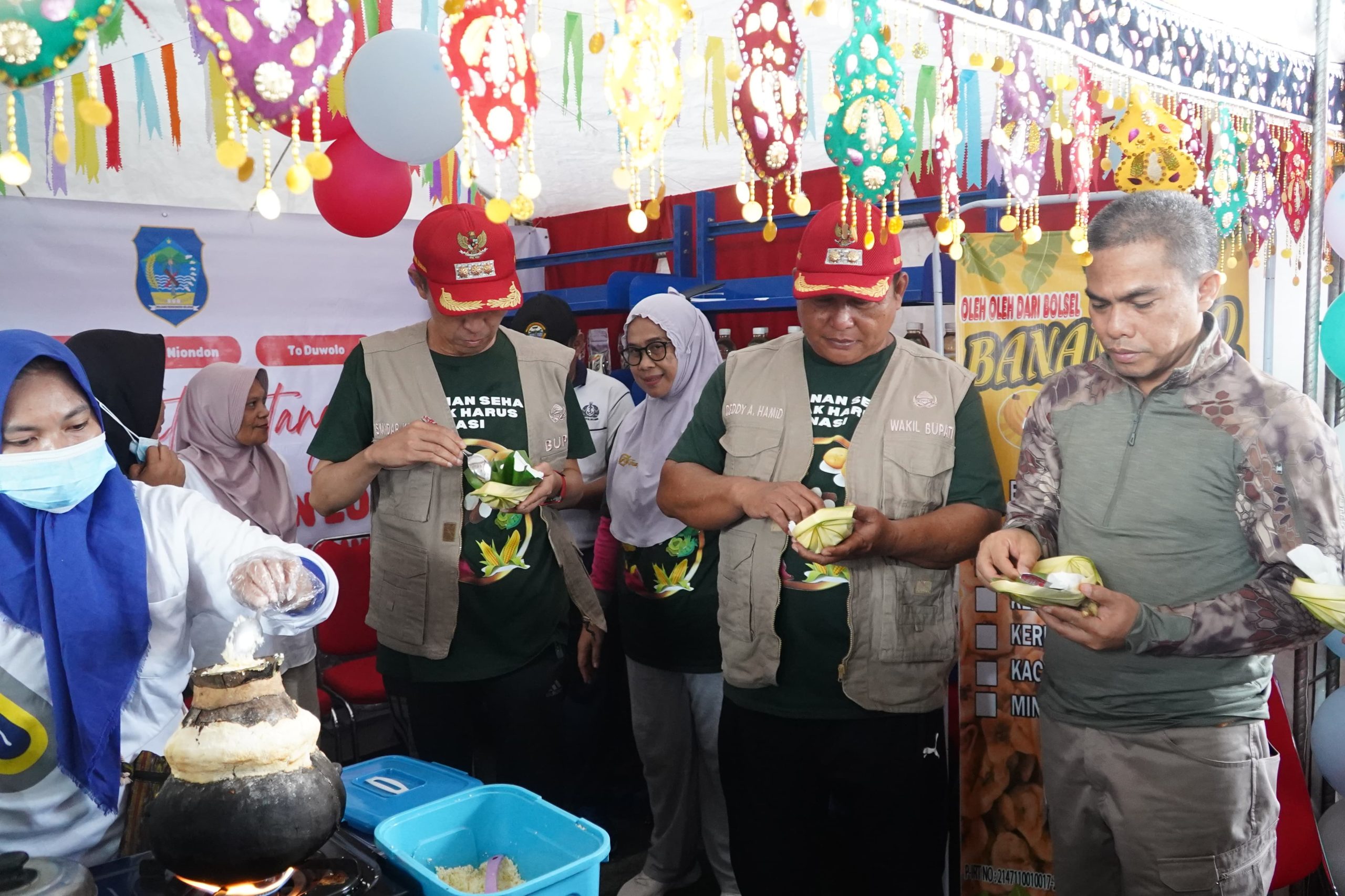 Bupati Iskandar Kamaru dan Wakil Bupati Bolsel Deddy Abdul Hamid saat menikmati makanan khas daerah Bolsel di Festival Pangan Lokal, Selasa (16/7/2024). Foto: Wawan Dentaw/bolmong.news