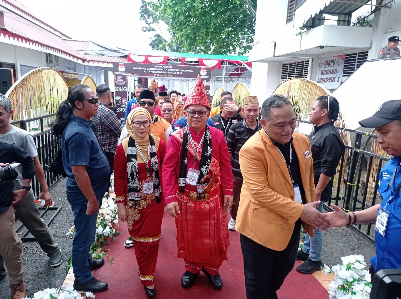 Tampak Pasangan Nayodo Koerniawan bersama Sri Tanti Angkara usai mendaftar di KPU Kota Kotamobagu, terlihat juga Sekjen Partai Hanura Benny Rhamdani sedang menyalami salah satu pendukung, pada Kamis (29/8/2024). Foto: Erwin Ch Makalunsenge/bolmong.news