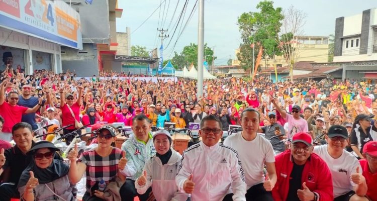 Tampak pasangan calon Wali Kota dan Wakil Wali Kota Kotamobagu, Nayodo Koerniawan-Sri Tanti Angkara (NK-STA) bersama para pimpinan dan pengurus Partai Politik pengusung NK-STA dan ribuan massa dalam acara peresmian rumah pemenangan NK-STA, Minggu (15/9/2024). Foto: Tim NK-STA.