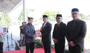 Tampak penulis buku perlawanan rakyat pedalaman Mongondow, Murdiono Mokoginta (kiri) saat menyerahkan buku kepada Pj Wali Kota Kotamobagu, Abdullah Mokoginta didampingi Ketua DPRD Kota Kotamobagu, Adrianus Mokoginta dan Sekretaris Kota Kotamobagu, Sofyan Mokoginta usai upacara peringatan Hari Pahlawan, Minggu 10 November 2024, di Lapangan Boki Hontinimbang Kotamobagu. Foto: dok/Bolmong.news