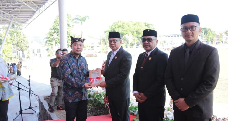 Tampak penulis buku perlawanan rakyat pedalaman Mongondow, Murdiono Mokoginta (kiri) saat menyerahkan buku kepada Pj Wali Kota Kotamobagu, Abdullah Mokoginta didampingi Ketua DPRD Kota Kotamobagu, Adrianus Mokoginta dan Sekretaris Kota Kotamobagu, Sofyan Mokoginta usai upacara peringatan Hari Pahlawan, Minggu 10 November 2024, di Lapangan Boki Hontinimbang Kotamobagu. Foto: dok/Bolmong.news