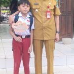 Tampak Bupati Bolsel Iskandar Kamaru bersama salah satu siswa SD