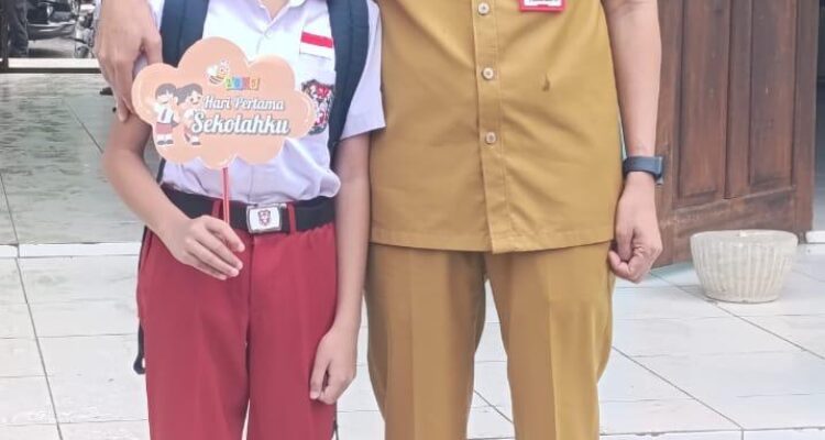 Tampak Bupati Bolsel Iskandar Kamaru bersama salah satu siswa SD